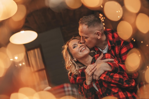 Una pareja casada feliz y auténtica pasa tiempo a solas en una cabaña decorada para Navidad.