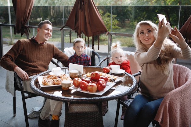 Una pareja casada con hijos, una hija y un hijo se toman una selfie en una mesa de un café. Feliz pareja tradicional, felicidad familiar.
