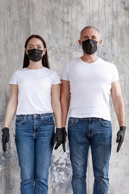 Foto una pareja casada con máscaras negras y guantes de goma negros.