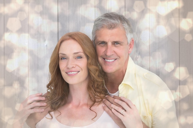 Pareja casual abrazándose y sonriendo contra el patrón de diseño de puntos brillantes de luz