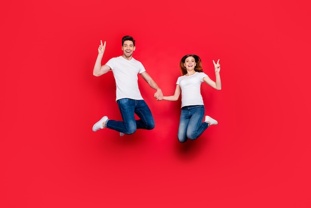 Foto pareja casual posando contra la pared roja