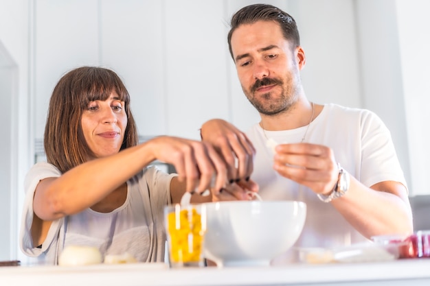 Una pareja caucásica cocinando juntos en casa, cocinando en confinamiento, cocinando con la familia.