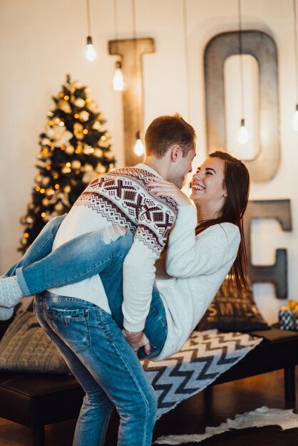 Pareja celebra la Navidad en un ambiente cálido en casa