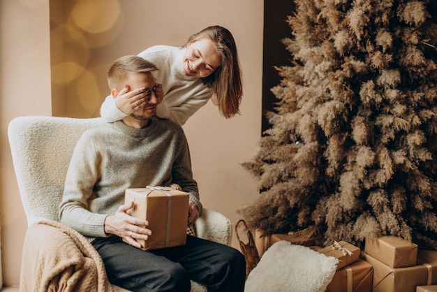 Pareja celebrando la Navidad por el árbol de Navidad