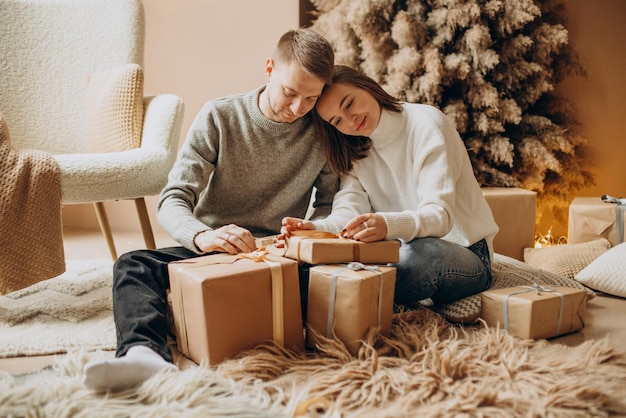 Pareja celebrando la Navidad por el árbol de Navidad