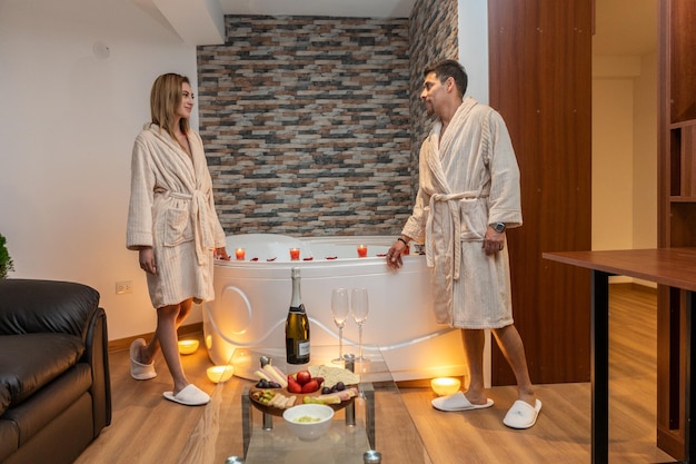 Pareja celebrando una velada romántica por San Valentín en un hotel con jacuzzi.