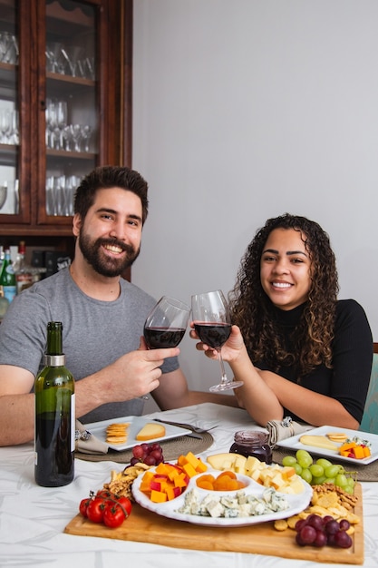 Pareja en cena romántica degustación de vino y queso. Pareja con bocadillos de vino y queso en invierno. Vertical