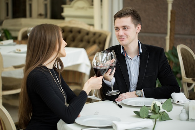 Pareja cenando en un restaurante y haciendo un brindis