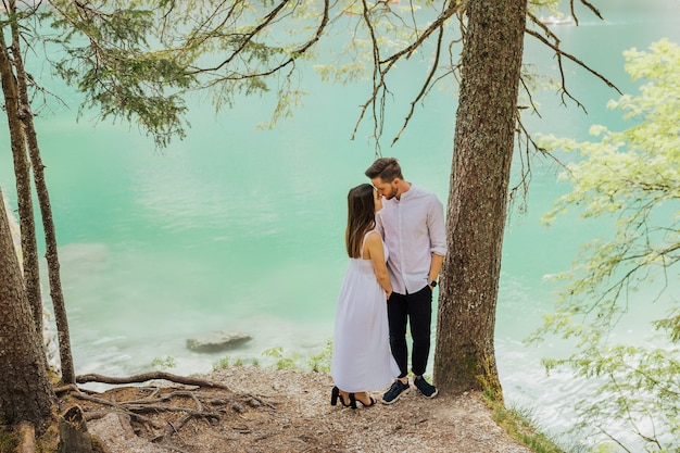 Pareja cerca del agua azul en el lago Braies.