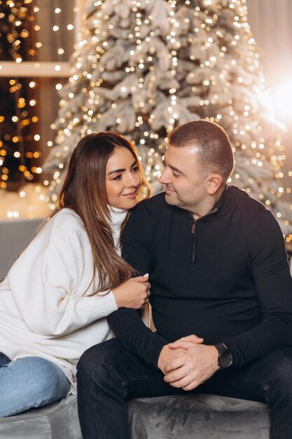 pareja cerca de árbol de navidad