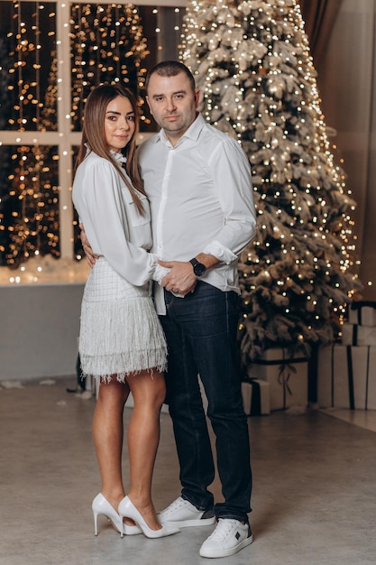 pareja cerca de árbol de navidad