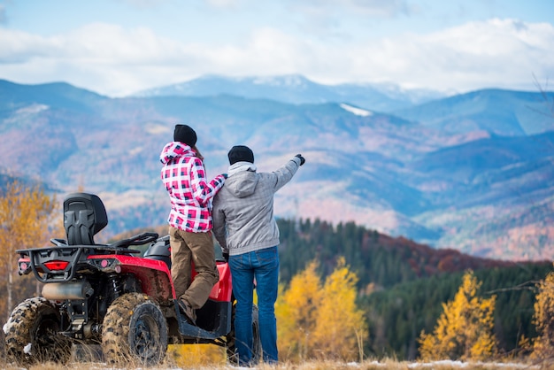 pareja cerca de quad roja