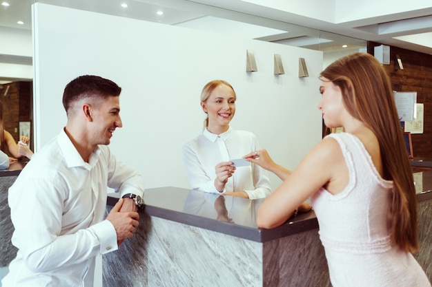 Foto pareja cerca de recepción en el hotel