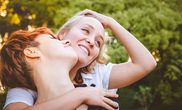 Pareja de chicas enamoradas abrazándose en un parque en un día soleado