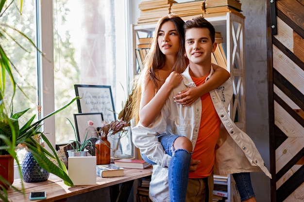 Pareja chico y mujer jugando en la habitación con libros