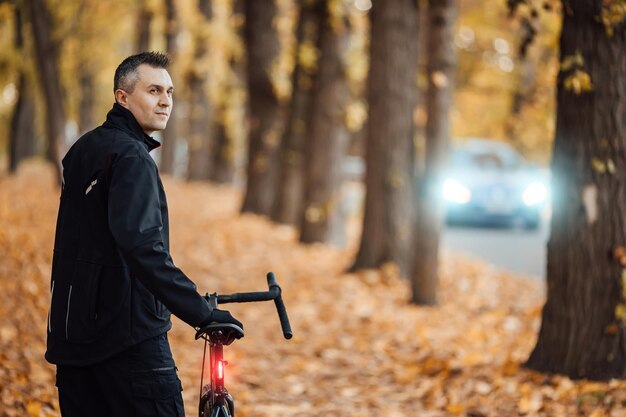 Pareja de ciclistas de montaña en bicicleta en el sendero para bicicletas en el bosque de otoño Ciclismo de montaña en el bosque del paisaje de otoño