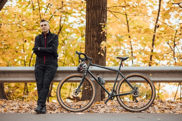 Pareja de ciclistas de montaña en bicicleta en el sendero para bicicletas en el bosque de otoño Ciclismo de montaña en el bosque del paisaje de otoño