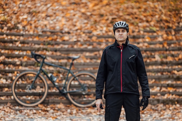 Pareja de ciclistas de montaña en bicicleta en el sendero para bicicletas en el bosque de otoño Ciclismo de montaña en el bosque del paisaje de otoño