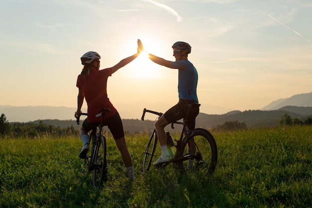 Una pareja de ciclistas que se dan un saludo el uno al otro