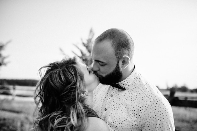 Pareja en una cita. Vestido morado. La novia y el novio. Camina por el campo. Historia de amor. Fotografía en blanco y negro.