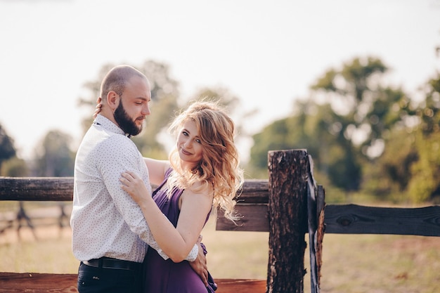 Pareja en una cita. Vestido morado. La novia y el novio. Camina por el campo. Historia de amor.