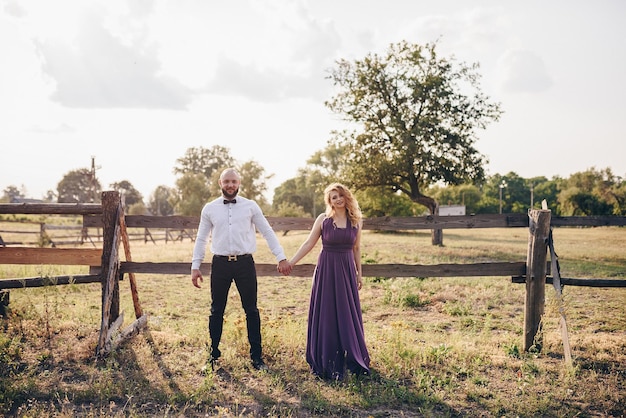 Pareja en una cita. Vestido morado. La novia y el novio. Camina por el campo. Historia de amor.