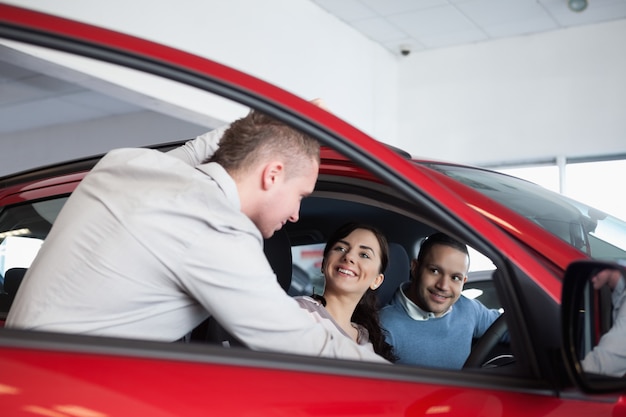 Foto pareja en un coche escuchando a un vendedor