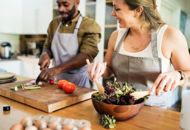 Una pareja cocina juntos en la cocina.