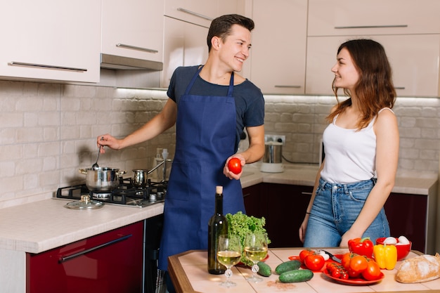 Pareja cocinando juntos en la cocina en casa