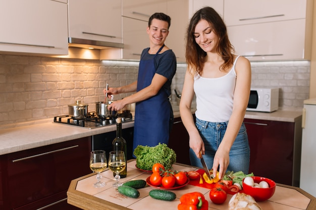 Pareja cocinando juntos en la cocina en casa