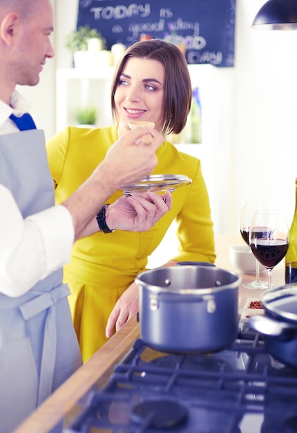 Pareja cocinando juntos en la cocina en casa