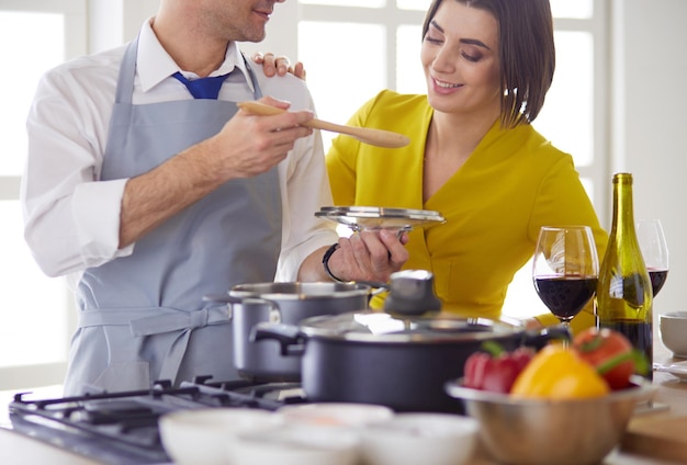 Pareja cocinando juntos en la cocina en casa