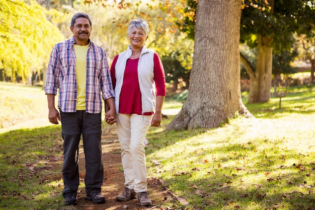 Pareja cogidos de la mano mientras está de pie en el camino