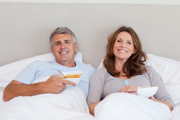 Pareja comiendo cereales en la cama