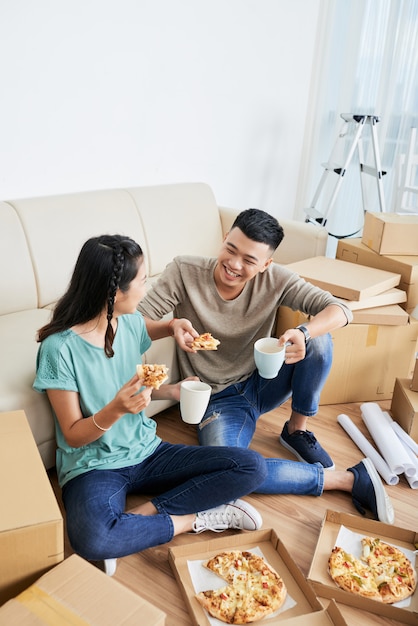 Pareja comiendo pizza en casa