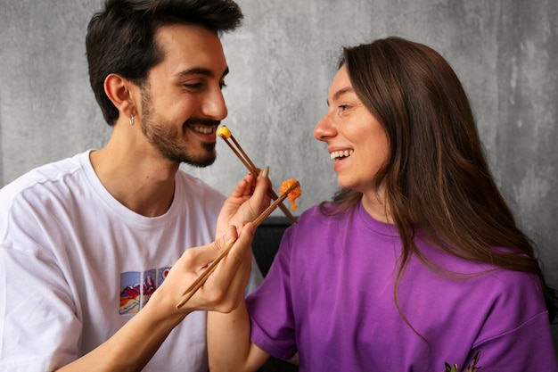 Foto pareja comiendo plato de salmón en el restaurante