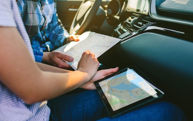 Pareja comparando un mapa en papel y un navegador gps