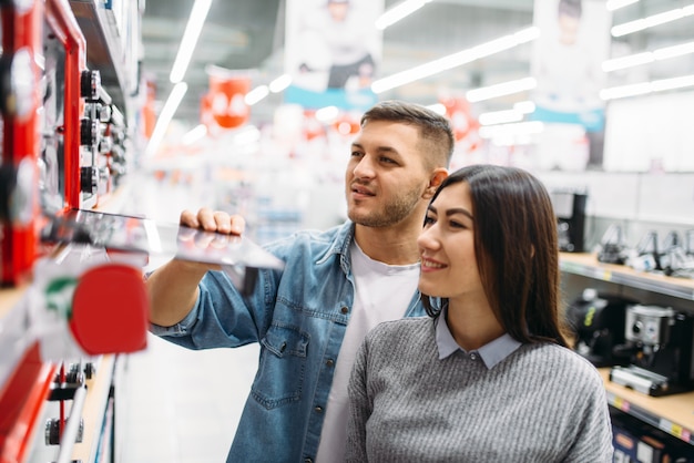 Pareja compra un horno eléctrico en un supermercado