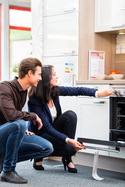 Pareja comprando cocina doméstica en showroom