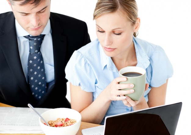 Pareja concentrada de empresarios leyendo el periódico drin