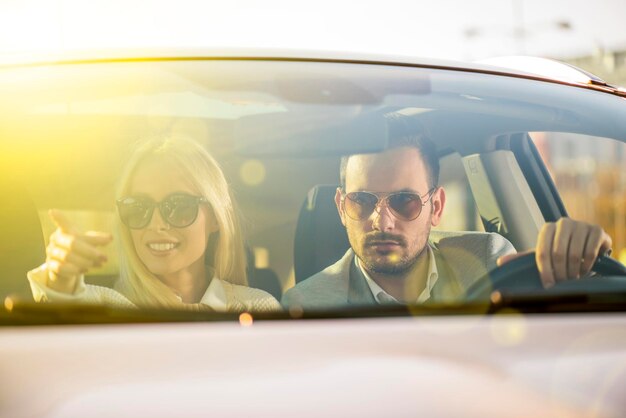 Pareja conduciendo un auto nuevo