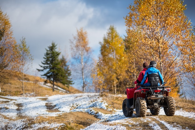 Pareja conduciendo una moto quad en un día soleado