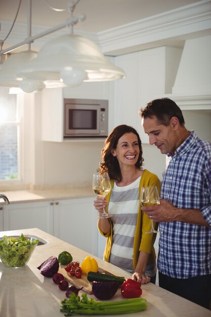 Pareja con copas de vino en la cocina