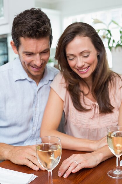 Pareja con copas de vino en la mesa de comedor