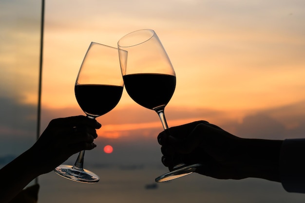 Pareja con copas de vino tinto en restaurante de lujo.