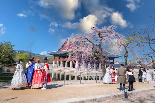 Foto una pareja coreana con el vestido tradicional coreano hanbok en el palacio de gyeongbokgung en la primavera de seúl, corea