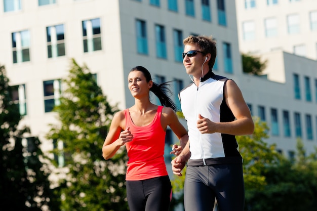 Foto pareja corriendo como deporte en la ciudad