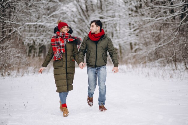 Pareja corriendo en un parque de invierno