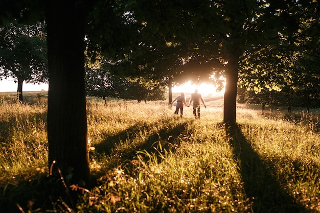 Pareja corriendo hacia la puesta de sol