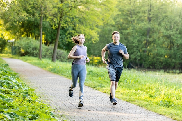 Una pareja corriendo por el sendero en el parque